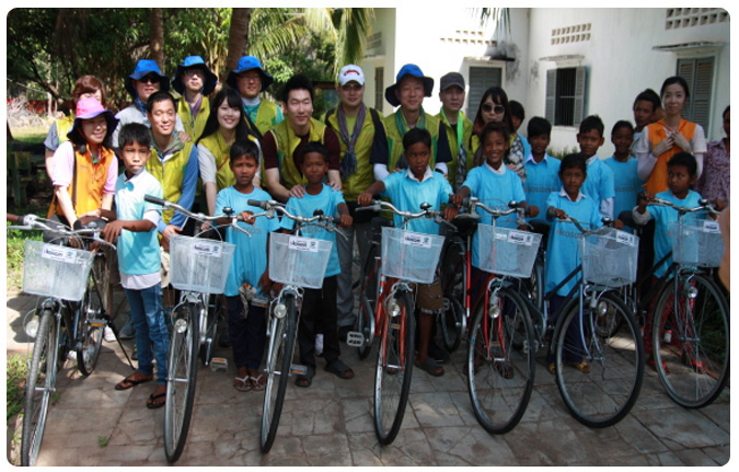 봉사단이 기증한 자전거를 앞에 세워두고 현지 아이들과 함께 기념촬영하는 모습