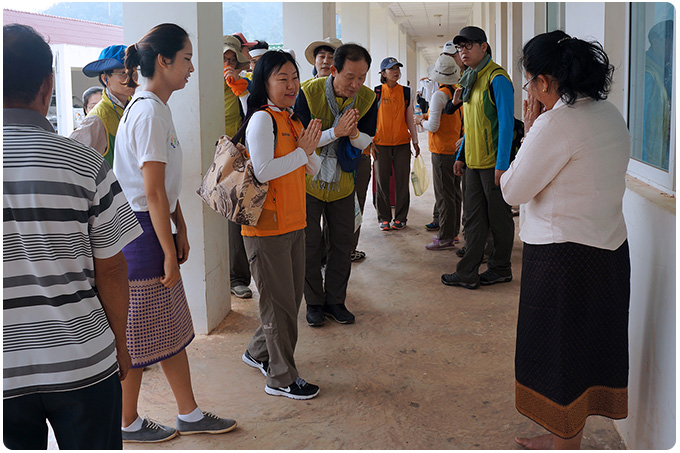 코스콤 봉사단을 따뜻하게 맞아주는 교장선생님과 여러선생님들의 모습입니다. 라오스식의 합장 인사를 나누고 있습니다.