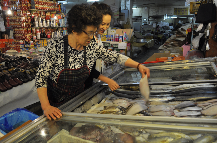 코스콤 해외사업부 차장이 전통시장 가는 날 행사에 참여, 대신시장에서 물품을 구입하고 있다.