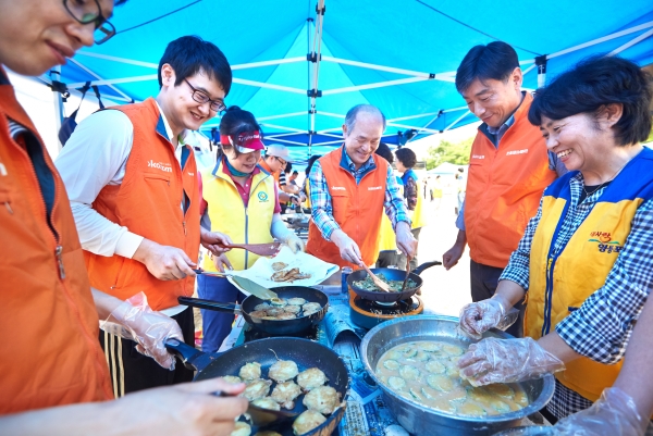 정연대 코스콤 사장(가운데)이 임직원, 지역 주민들과 함께 전 부치기에 나서고 있다.