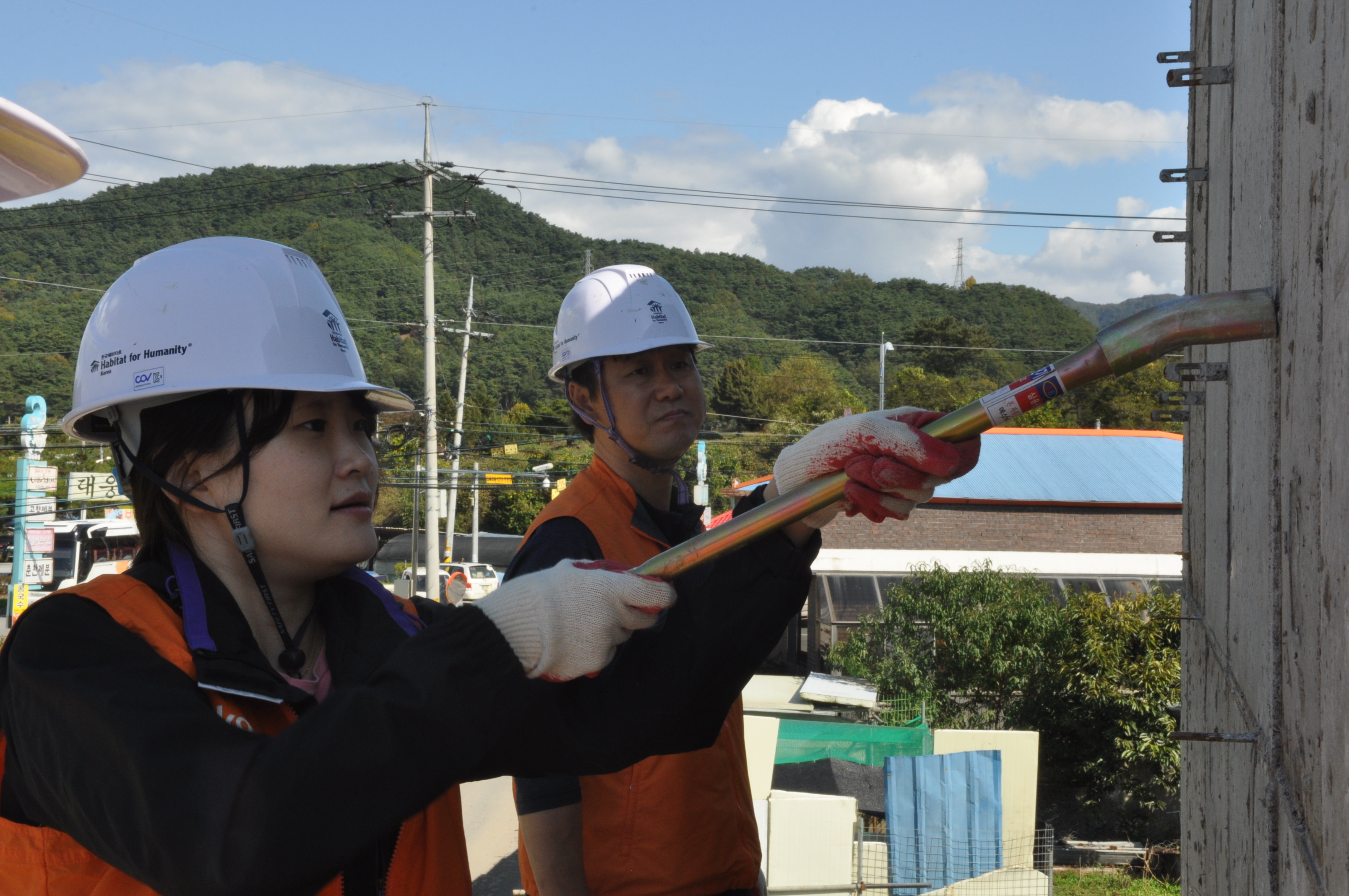 외부벽에 작업하는 봉사자의 모습